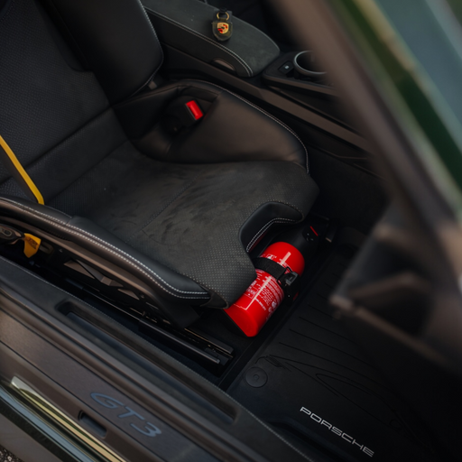 Porsche 992.2 folding carbon fiber bucket seat with OEM fire extinguisher kit and genuine Porsche mounting accessories